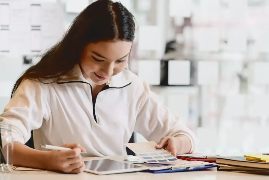 Jugendliche sitzt vor Unterlagen und lernt